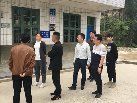 A group of people standing in front of a buildingDescription automatically generated